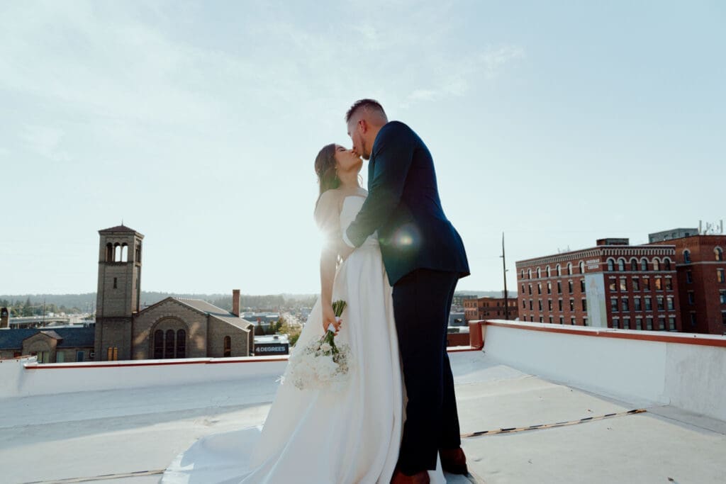 Bride and groom kissing on rooftop