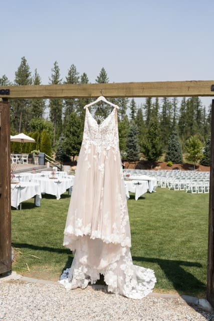 Wedding dress hanging outdoors at venue