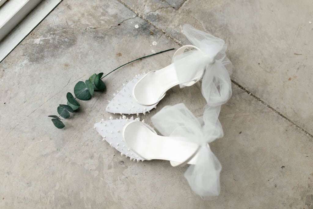 Bridal shoes with pearl details and tulle bows on floor